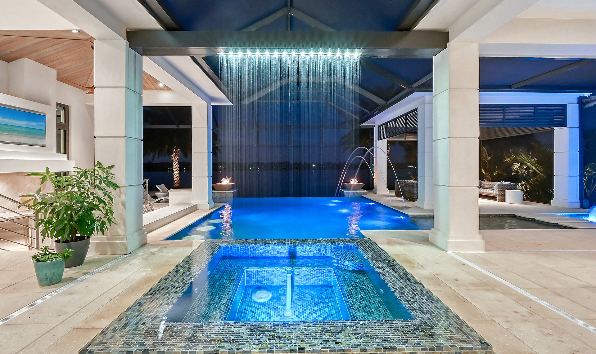 Vivid lighting and sparkling water features create a dramatic lakeside setting.