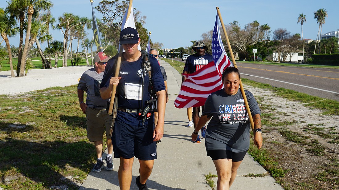 Longboat Key Firefighter Paramedic Chris O'Brien (left) walks in front of the group with Michelle Floril, who is traveling the east coast with Carry the Load.