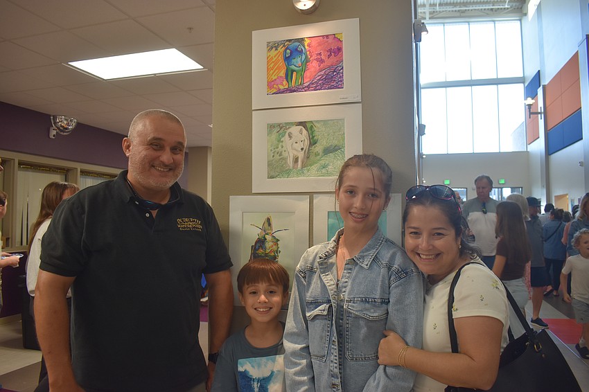 Father Nicolas Alvarado, brother Diego Alvarado, seventh grade artist Olivia Alvarado and mother Cristina Urizar enjoy looking at the art. Olivia Alvarado created the two arctic wolf pieces and her father Nicolas said he is in awe of her talent and doesn't know where she got it from.