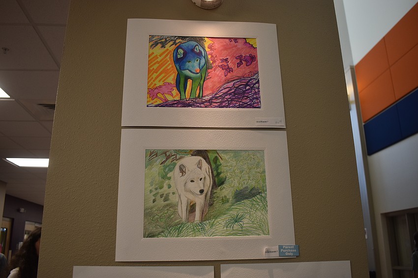 Olivia Alvarado, a seventh grader at Mona Jain, says arctic wolves remind her of the moon and she loves the moon. The top piece is a colorful, abstract version of a wolf, while the bottom was created to be more realistic.