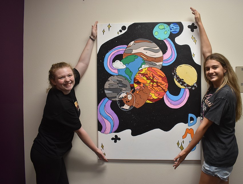 Mollie Schaeffer and Avery Wienczkowski are both eighth graders who worked together to create a bright and colorful piece with planets featuring a bull, their school's mascot. Schaeffer said they wanted it to be cartoonish and used bold outlines to make it pop.