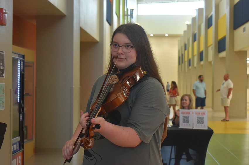 Elizabeth Argo, an eighth grader who plays viola, was asked the day of the art show during second period to perform at the art show.