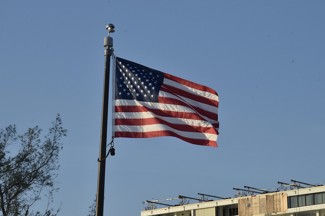 The flag flies over the pier on Siesta Key Beach.