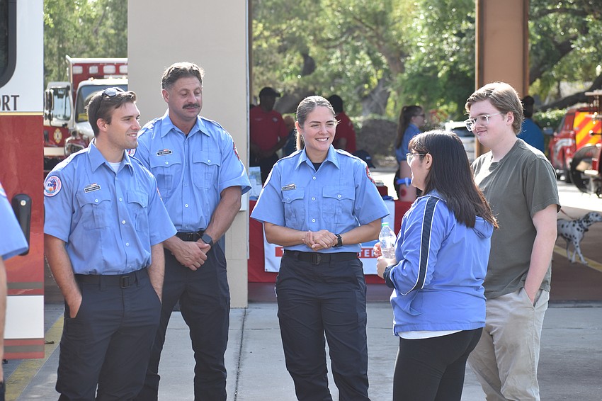 Firefighters Dakota Haberland, Charlie Reeder and Christina Newport talk with Jessica Carrillo,  and her fiancee Dawson Wood