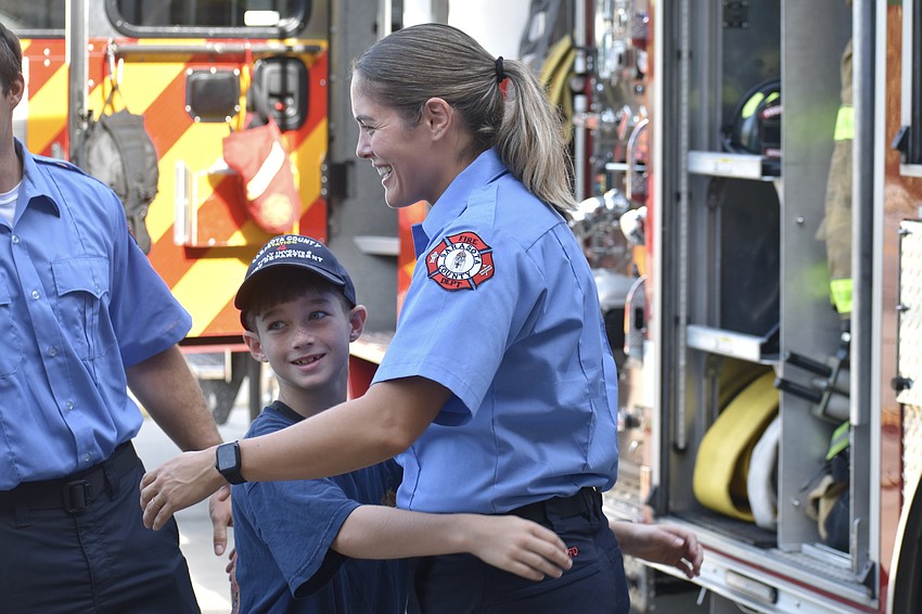 Mason Foscolos, 9, hugs firefighter/EMT Christina Newport.