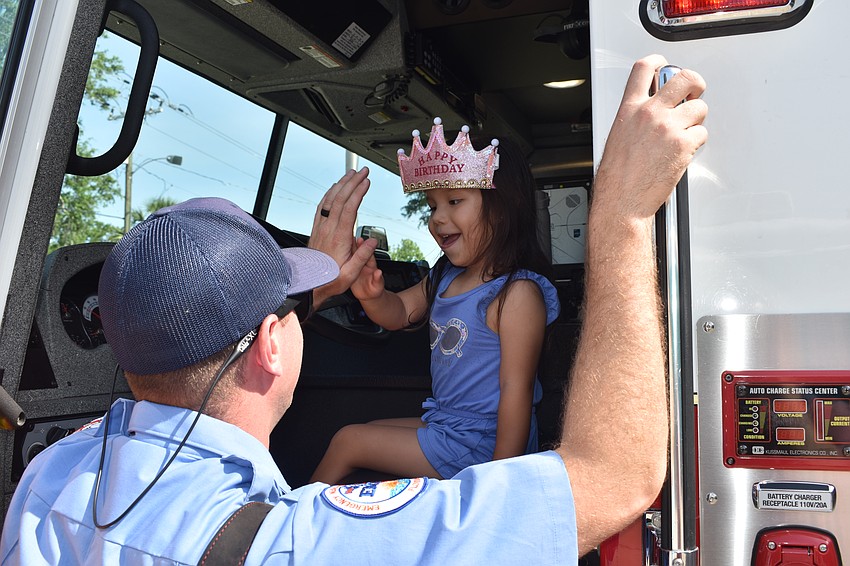 Tyler Curcio helps Mia Isabella Urquiza, 4, take the drivers' seat.