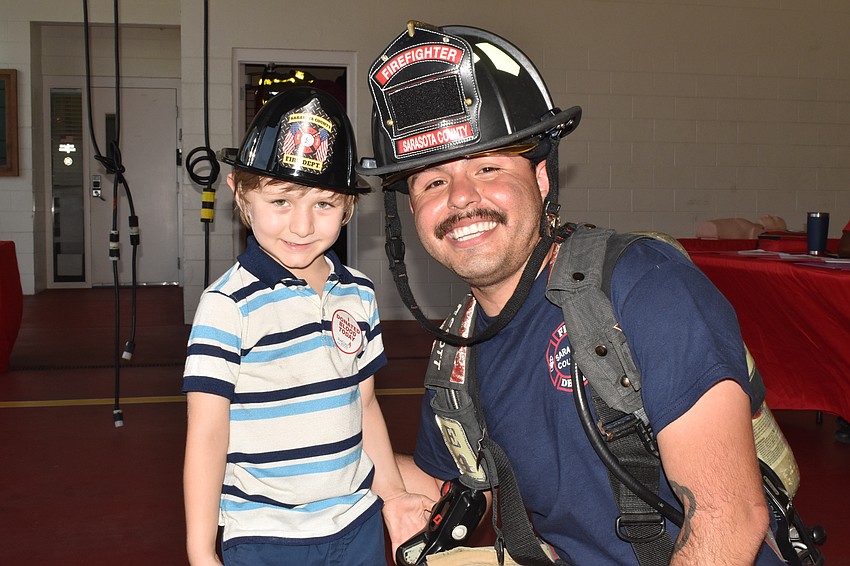 Alejandro Castro, 5, poses with firefighter/paramedic Diego Gutierrez.