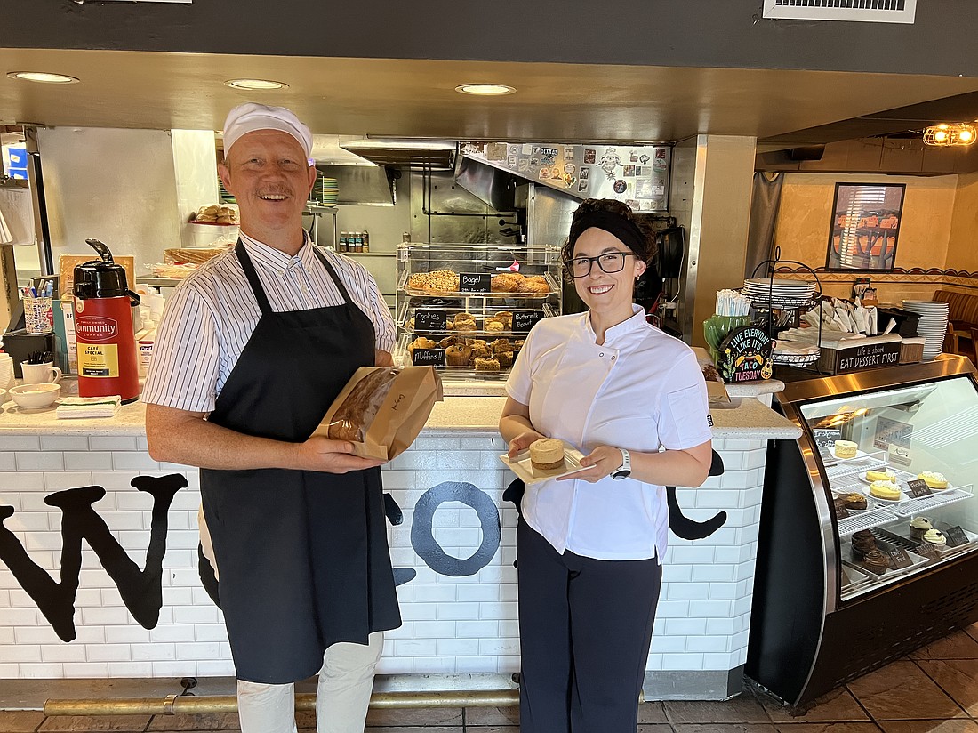 John Ogle holds a loaf of sourdough bread and Leah Ogle has her one-of-a-kind Irish Cream and Coffee Brie cheesecake. They operate From Butter with Love Bakery weekday mornings in Mossfire Grill in Five Points.