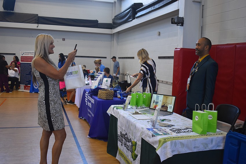Allison Adams, development outreach coordinator of Team Tony Cancer Foundation, takes a photo of Darlando Bailey, the community relations director for The Villas of Holly Brook, a senior living community. Adams says she enjoys cross promoting other businesses as events.