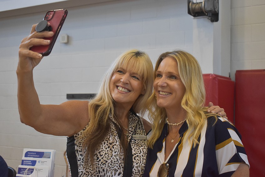 Allison Adams, development outreach coordinator of Team Tony Cancer Foundation and Shari Schwartz, clinical liaison at Encompass Health Rehabilitation Hospital share information about each of their workplaces and pose for a photo together.