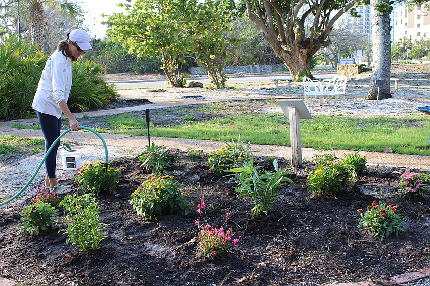 Cyndi Seamon gives a final watering to the Butterfly Garden.
