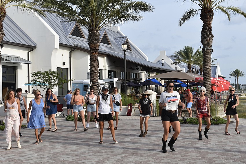 Lindsey Dittenber (out front in the Mustang T-shirt) leads a line dancing class in Gateway Park.