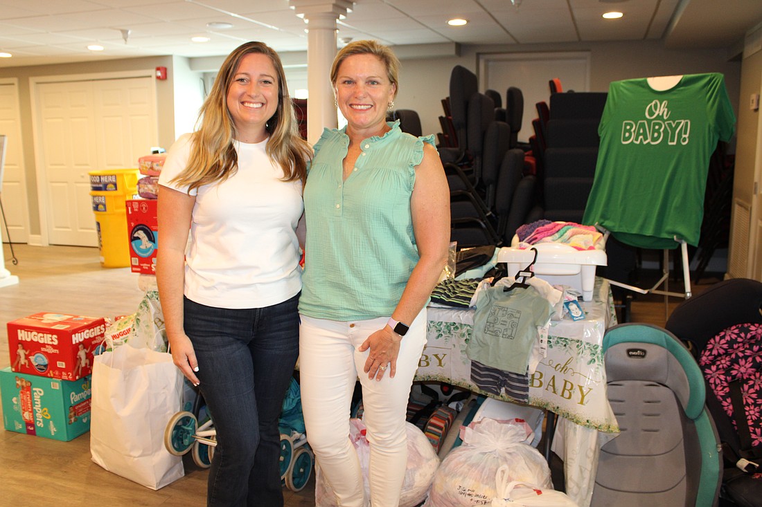 Porshia Lococo and Meredith Piazza, two of the leaders with Riverview High School's Cyesis parenting program, speak with members of Longboat Island Chapel who held a donation drive this month.