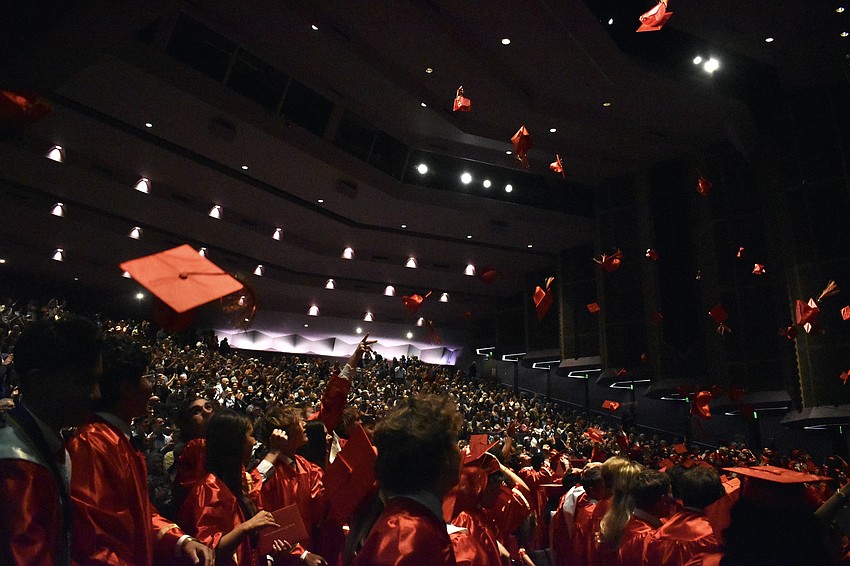 Students toss their caps into the air.