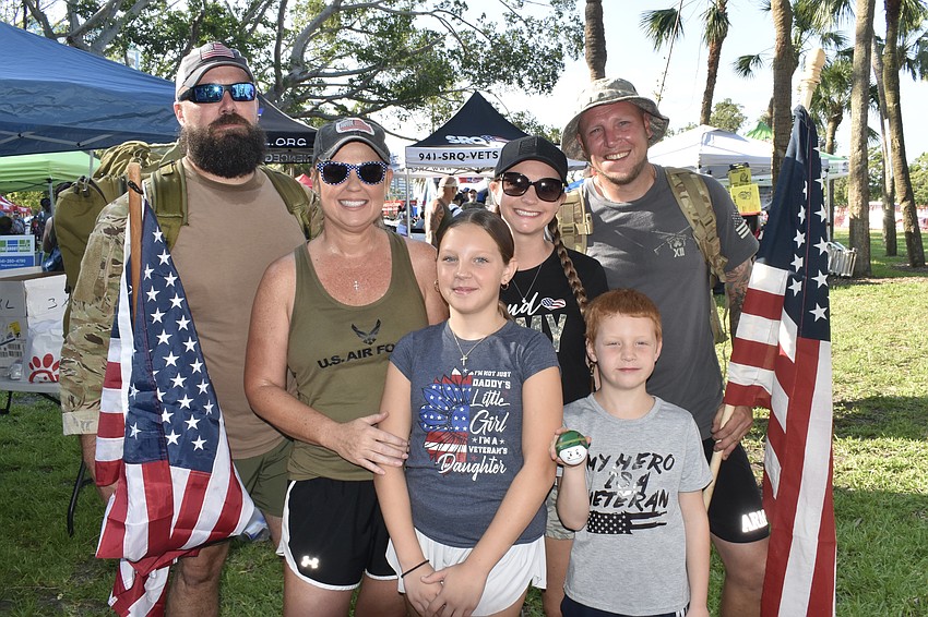 Air Force veteran Jason Westlake and his wife Colie Westlake pose with Riley Romano, 10, her mother Ashley Romano, brother Ryan Romano, 7, and father Michael Romano, an army veteran.