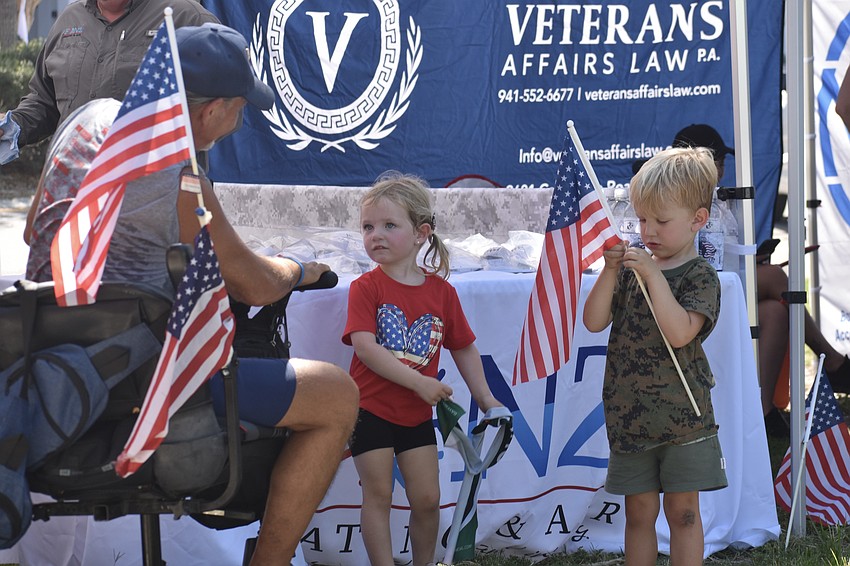 Military veteran David Mattis, a car recipient, talks with Kimber Fonville, 3, and her brother Kane Fonville, 4.