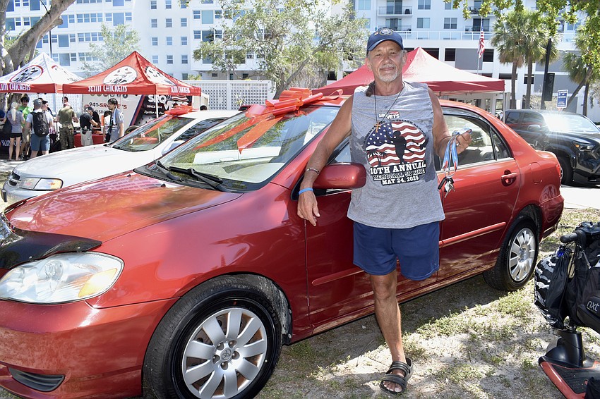 Navy veteran David Mattis stands with his new car.