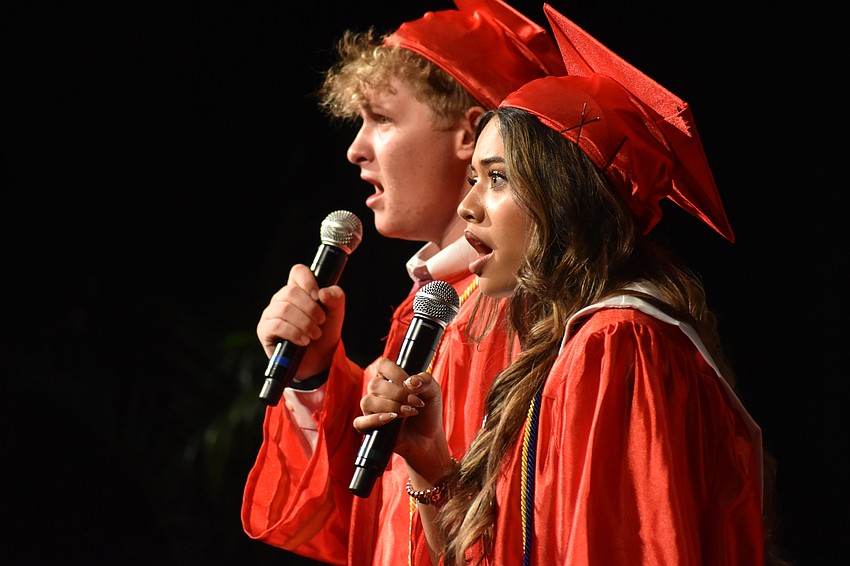 Graduates Andrew Blessitt and Samantha Aguilera sing the national anthem.