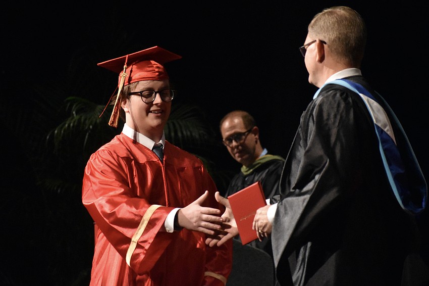 Brennan Cheperka shakes hands with Principal Ben Hopper.