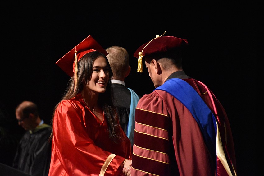 Sophia Cusumano shakes hands with John Belmonte, Superintendent of Catholic Education at the Diocese of Venice in Florida.