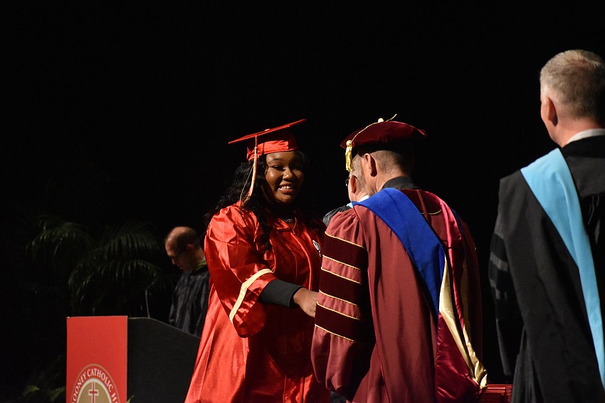 Alana Jenkins shakes hands with John Belmonte, Superintendent of Catholic Education at the Diocese of Venice in Florida.