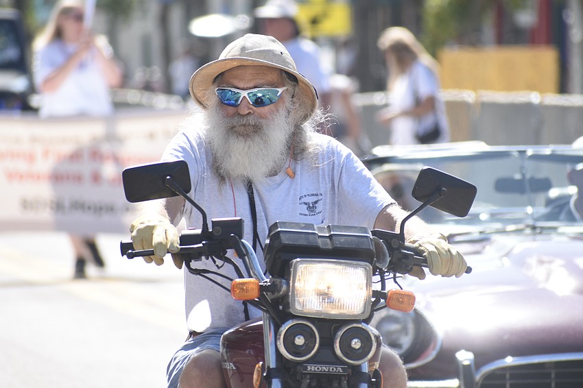 Doc Fox approaches on a motorcycle.