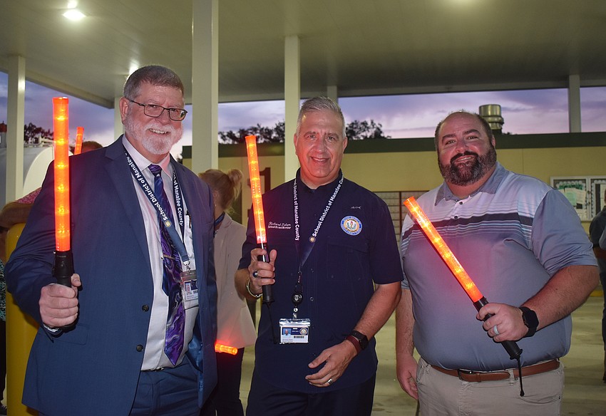 Paul Gansemer, executive director of adult, career and technical education, waves alongside school board members Richard Tatem and Chad Choate.