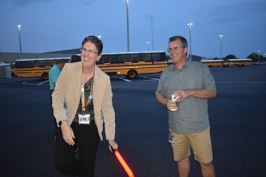 School board members Heather Felton and Charlie Kennedy send off the bus drivers on the last day of school.