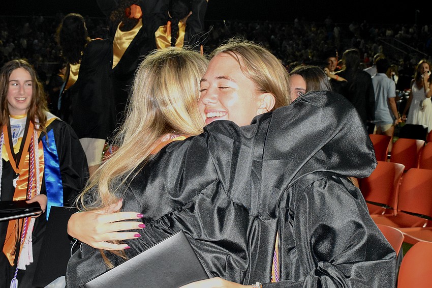 Ashley Bailey hugs her friend and fellow graduate Reagan Hughes.