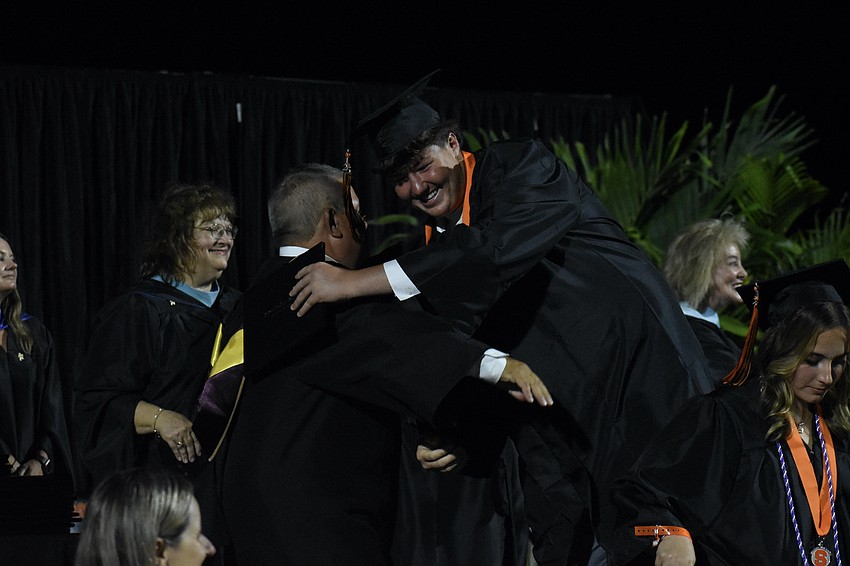 School Board Chair Tim Enos greets Jaxon Smith.