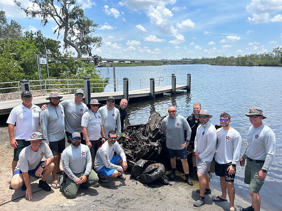 The Manatee County Sheriff's Office Dive Team takes a celebratory photo after pulling a sunken minivan out of the Manatee River.