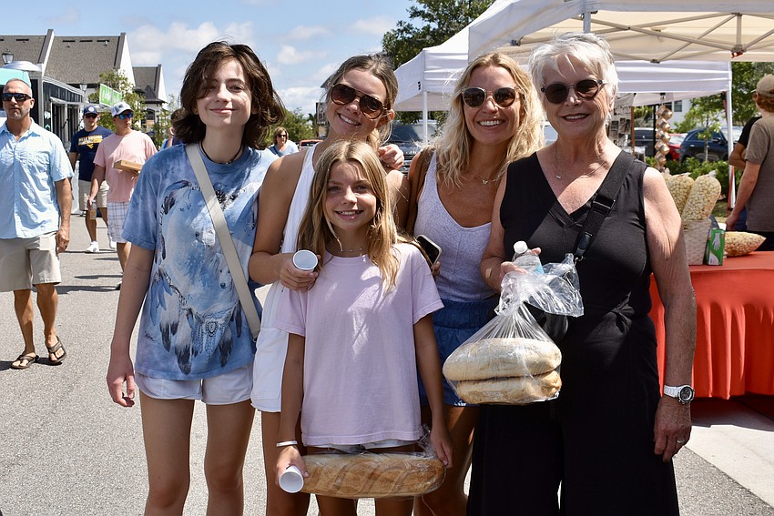 Elsie Williams stands with a loaf from Bread Bandits in front of her sisters Lainey and Penny Williams, her mom Kelly Williams and her grandma Nancy Moran.