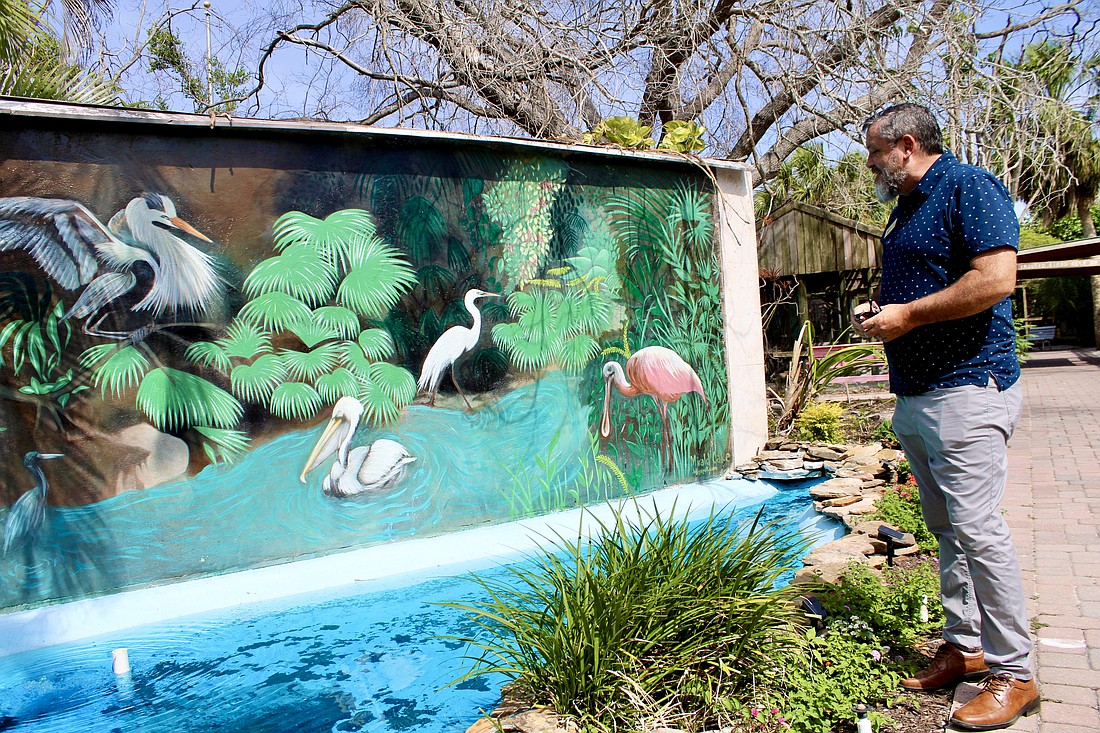 Brian Walton, executive director of Save Our Seabirds, points out some improvements made to a mural centrally located at the facility as part of a wider revitalization effort.