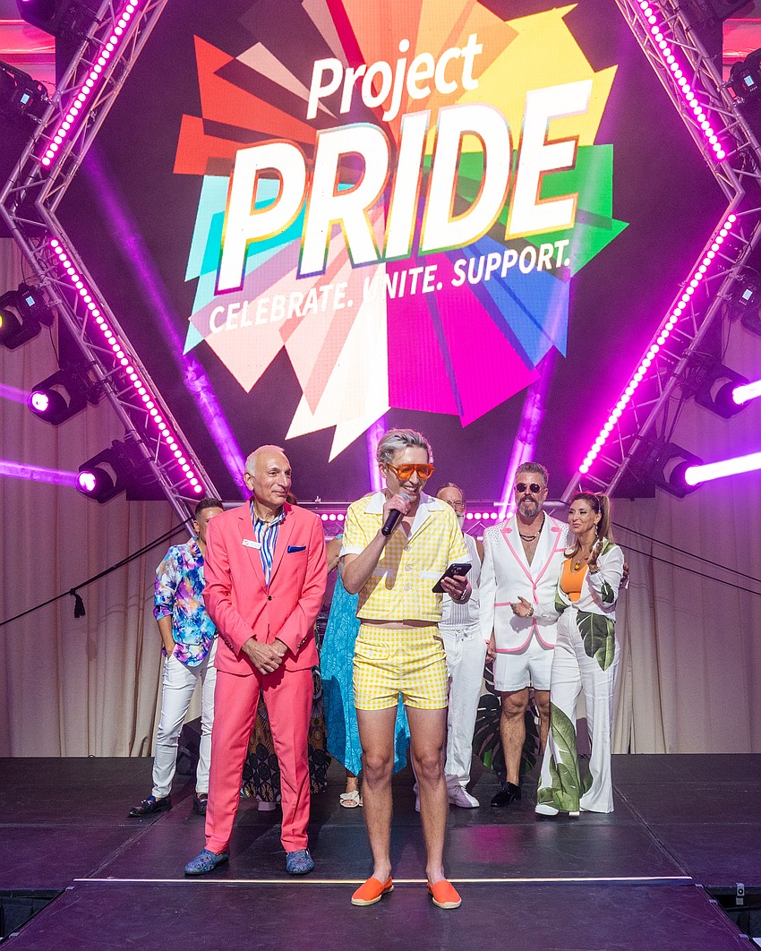 New Project Pride SRQ President Justyn Hunter-Ceruti speaks to the crowd while Vice President Harry Cicchetti, Immediate Past President  Jason Champion and Donna Koffman look on.