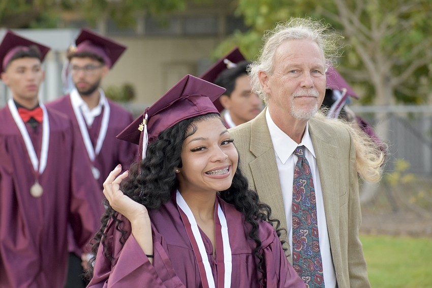 Samiyah Allbritton walks beside English teacher Michael Harvey.