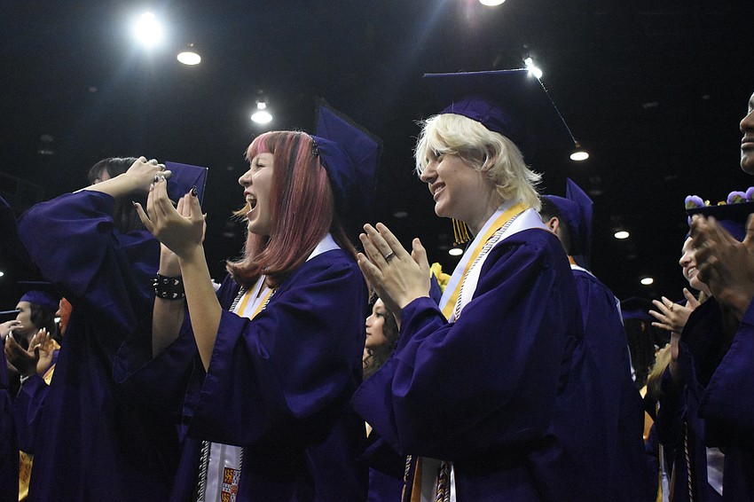 Yasmine Carr and Dale Burgess applaud as the ceremony concludes.