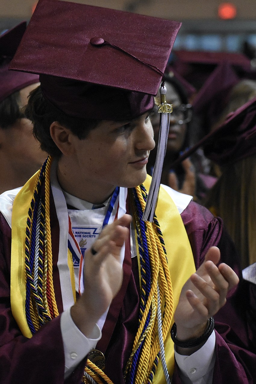 Conor Fitzgibbons applauds during a speech.
