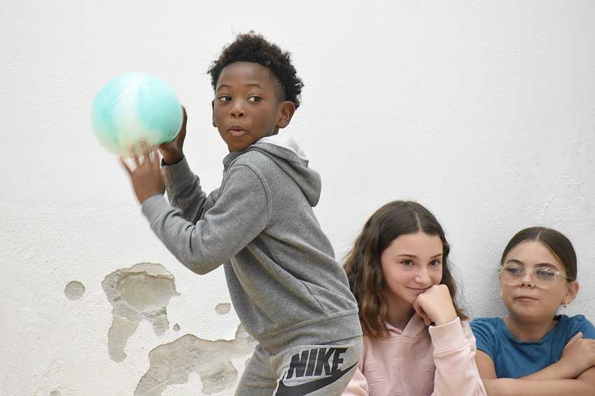 Jeremiah Turner, 9, tosses a ball as Sophia Zaczyk, 10 and Vera Partie, 9, look on.