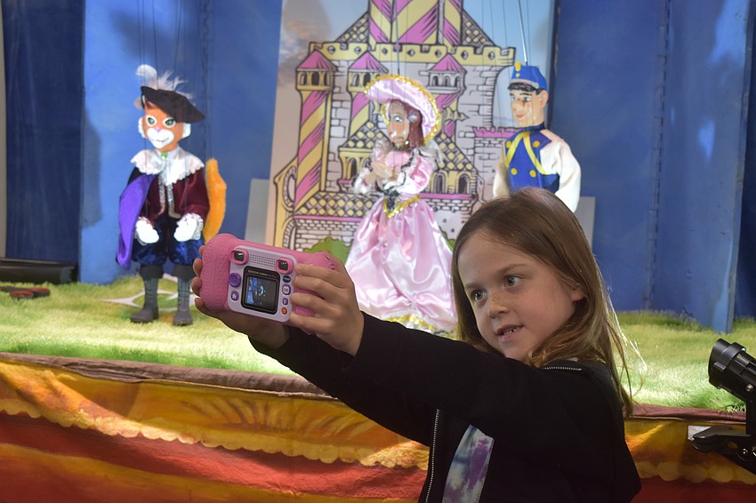 Alaina Lininger, 6-year-old Lakewood Ranch resident, is eager to take a selfie with the puppets with her camera.