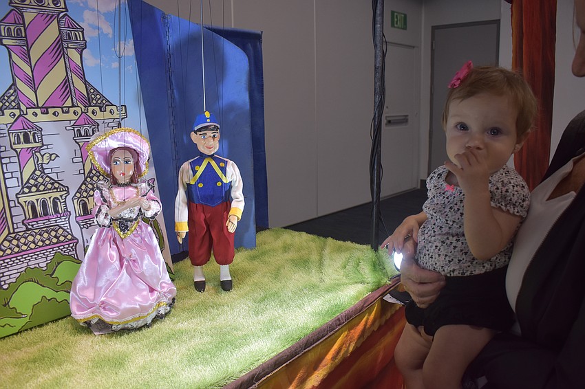 Ten-month-old Gabriella Born is shown the puppets up close by her grandma  Caren Starala.