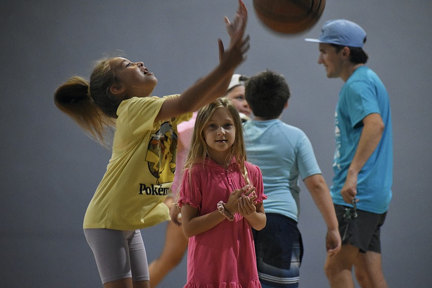 Olivia Sarkisova, 8 and Callie Crawford, 8, play with a basketball.