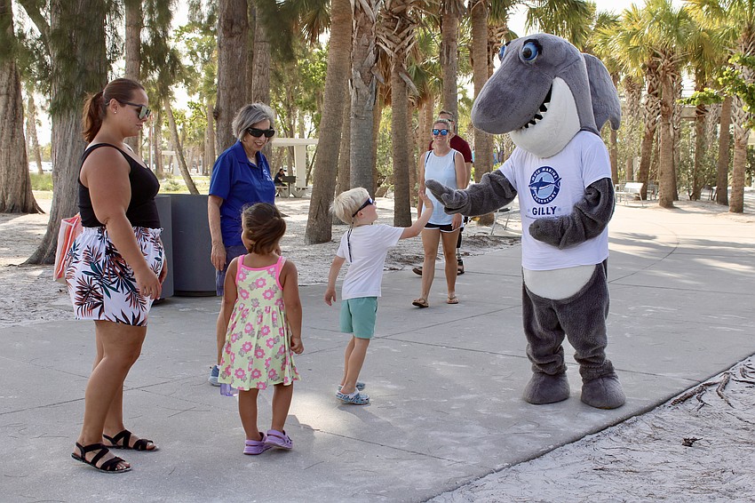 Clif Lansford, 4, gives Gilly, the shark mascot for Mote Marine Laboratory and Aquarium, a high five at a World Ocean Day event.