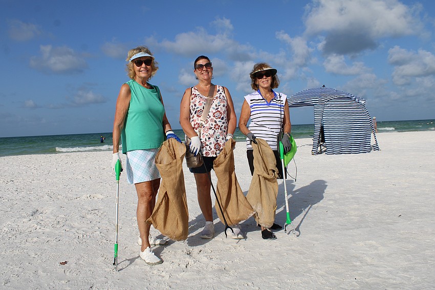 Carol Smith, Susan Rini and Diann Brown help out with the cleanup at Siesta Beach.