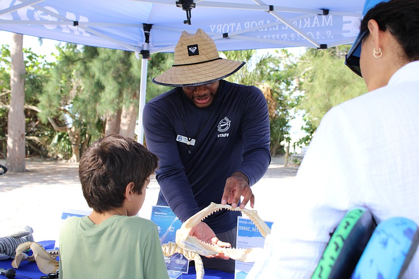 John Emmanuel Perry, education specialist with Mote Marine Laboratory & Aquarium, shows off a set of shark teeth on World Ocean Day.