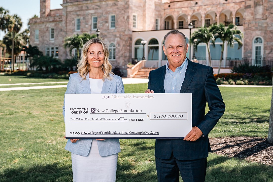 Executive Director and Vice President of Advancement of the New College Foundation holds a check from the DSF Charitable Foundation next to New College President Richard Corcoran.