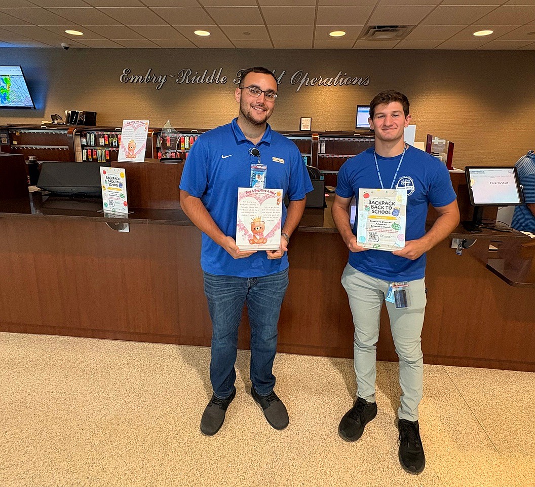 Embry-Riddle Aeronautical University flight students Peter Stewart Jr. and Robert Villa hold flyers for Michael's 'Ohana's backpack drive. Courtesy photo