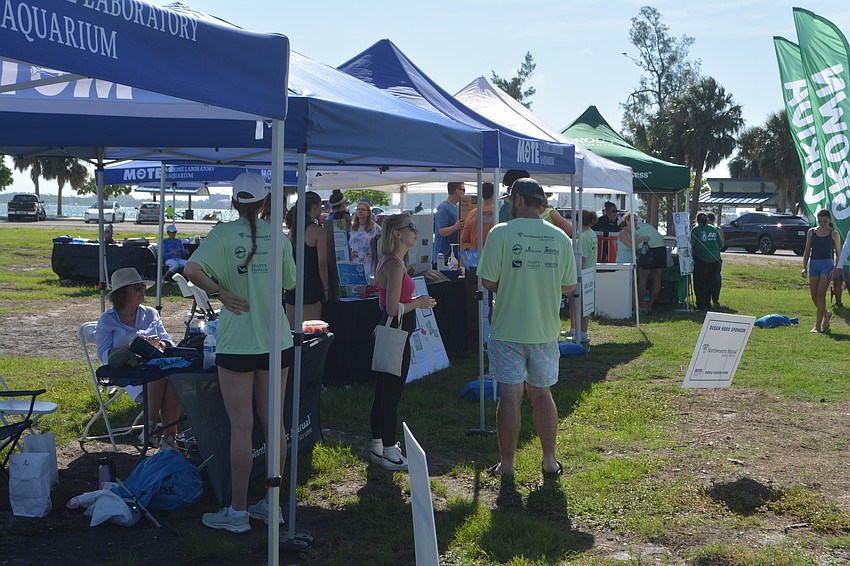 Volunteers gather around the student presentation booths and learn more about ocean conservation.