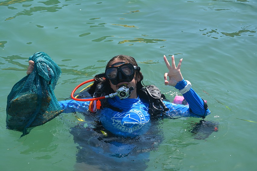 Mote Marine's PR coordinator, Kathryn Gentile, poses with her scuba gear and trash she collected from her dive.