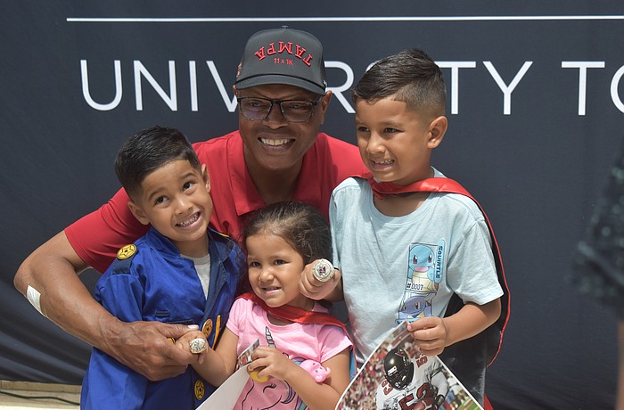 Shelton Quarles poses for a photo with Rowan, 4, Madison, 3, and Grayson Izaguirre, 6. If they were superheroes, Rowan would be the Hulk, Madison would be a unicorn and Grayson would be Spiderman.