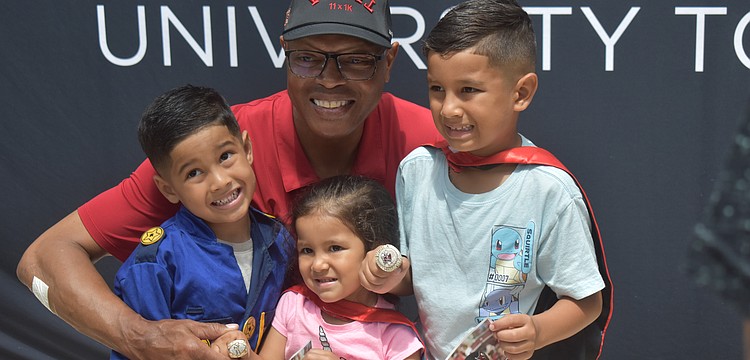 Shelton Quarles poses for a photo with Rowan, 4, Madison, 3, and Grayson Izaguirre, 6. If they were superheroes, Rowan would be the Hulk, Madison would be a unicorn and Grayson would be Spiderman.